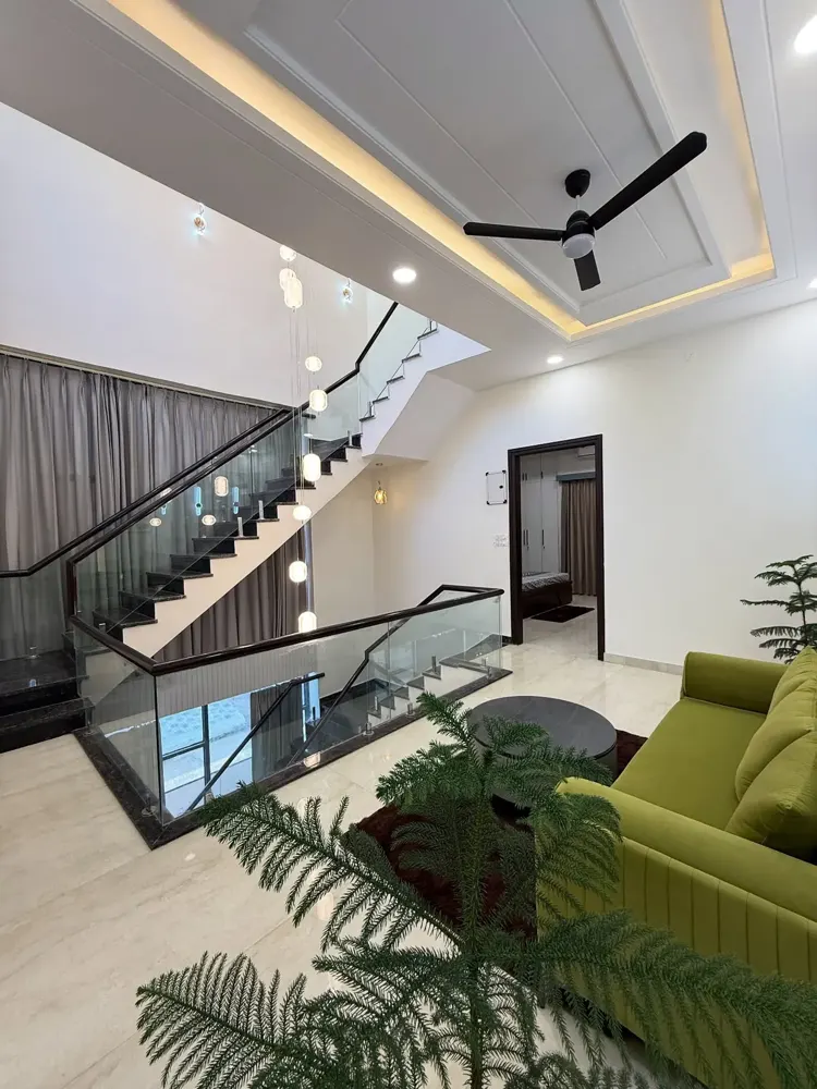 Staircase void with glass railing and natural light in a home designed by Foxrun